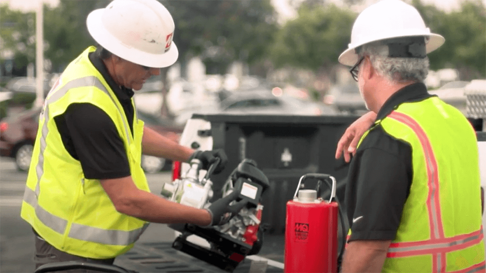 Photo of two workers examining small engine